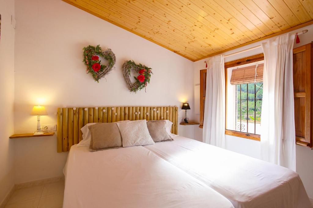 Dormitorio de matrimonio con techo de madera y ventana a la montaña