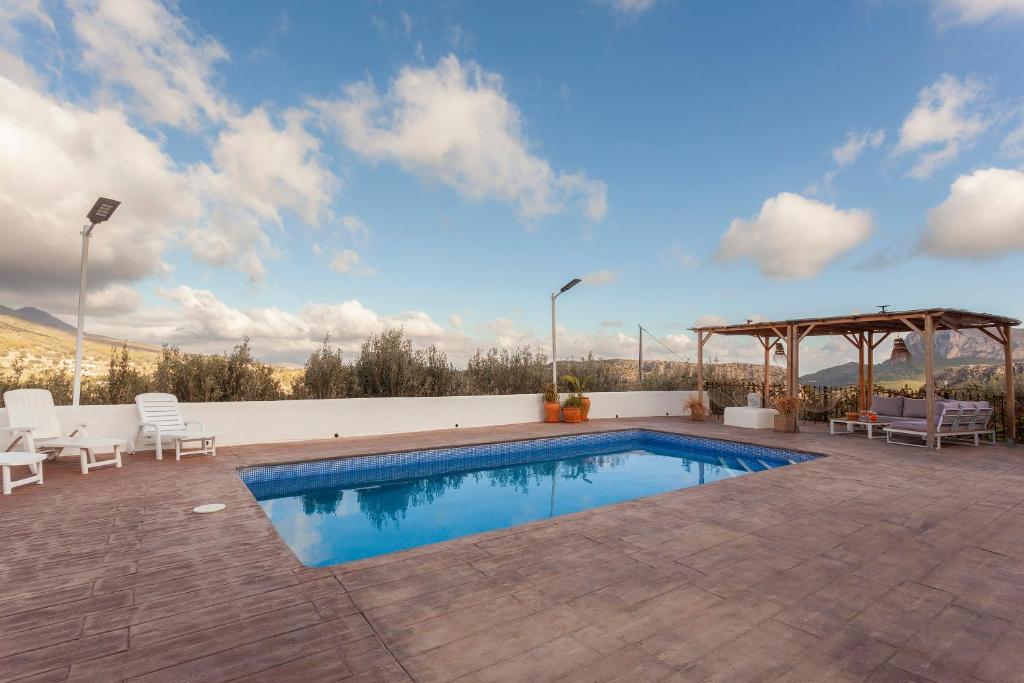 Terraza soleada con piscina, hamacas y porche de madera